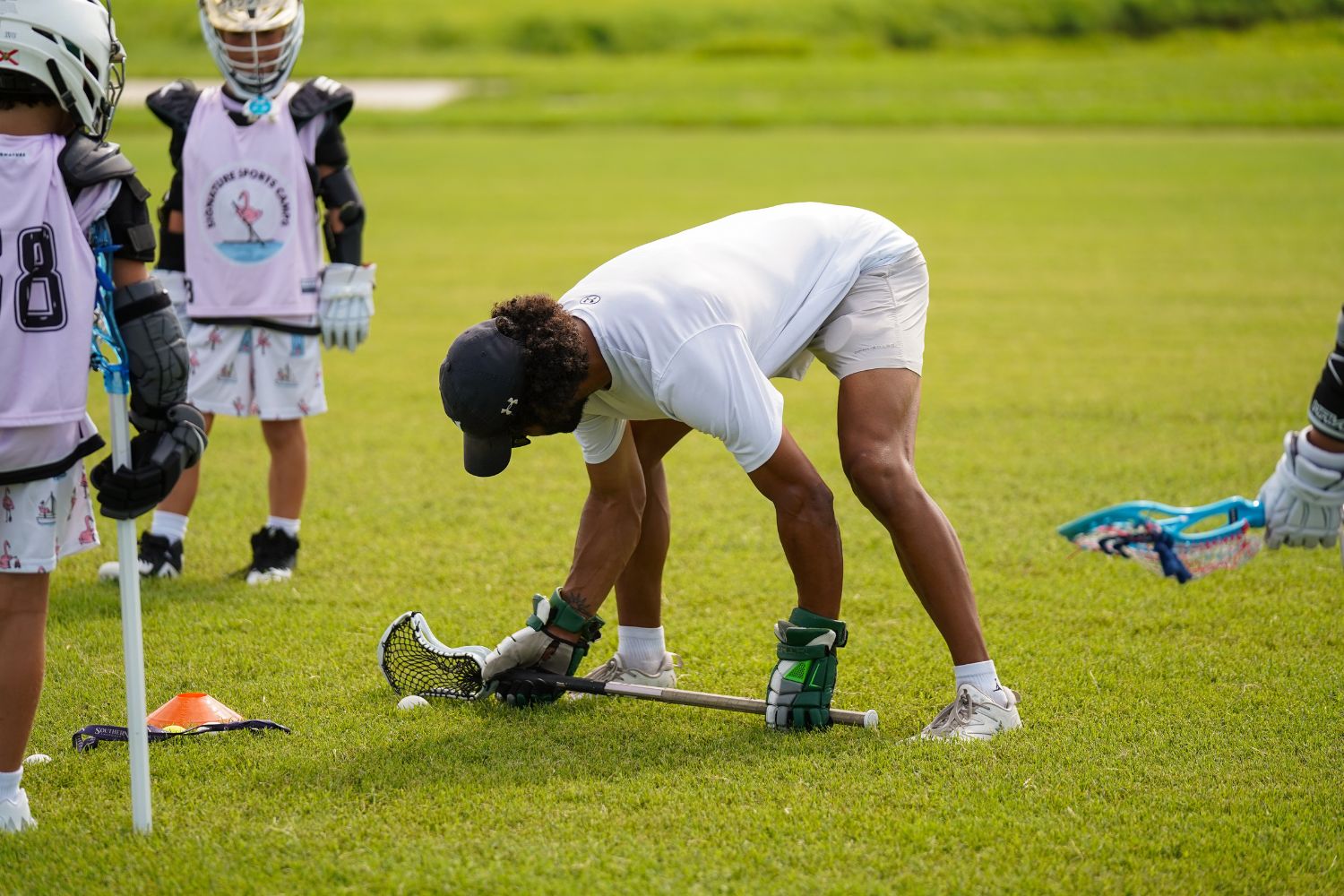 Boys lacrosse group receiving instruction from a coach during overnight sports camp