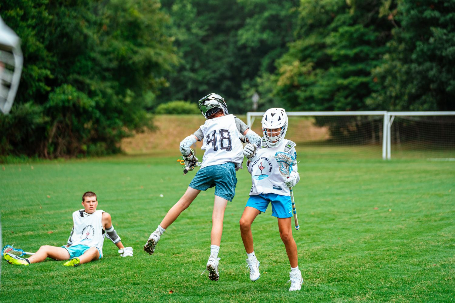 Boys at lacrosse camp celebrating during a scrimmage