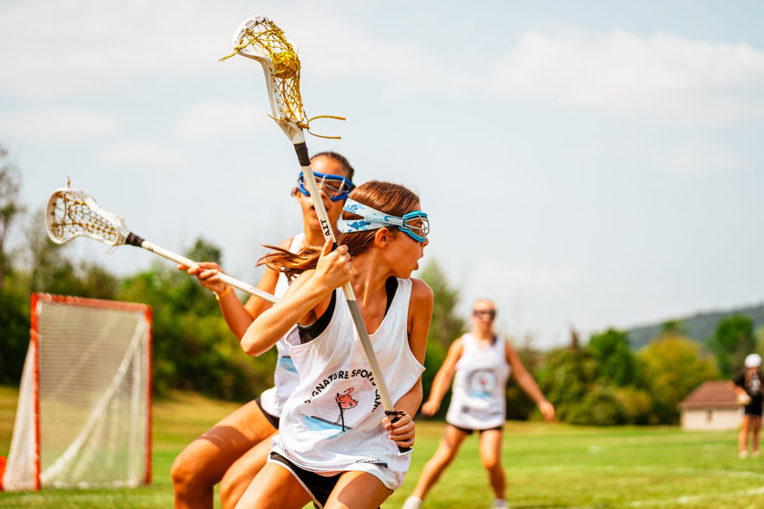 Girls lacrosse players during a scrimmage at overnight sports camp