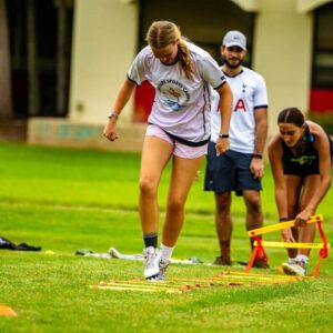 Girl wearing signature sports camp jersey practicing speed and agility drills during soccer camp