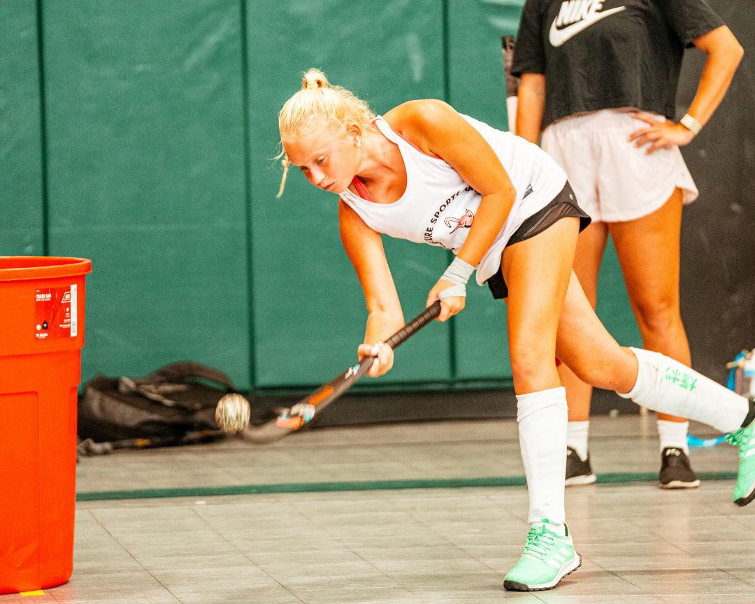 Girl practicing field hockey drills at signature sports camp