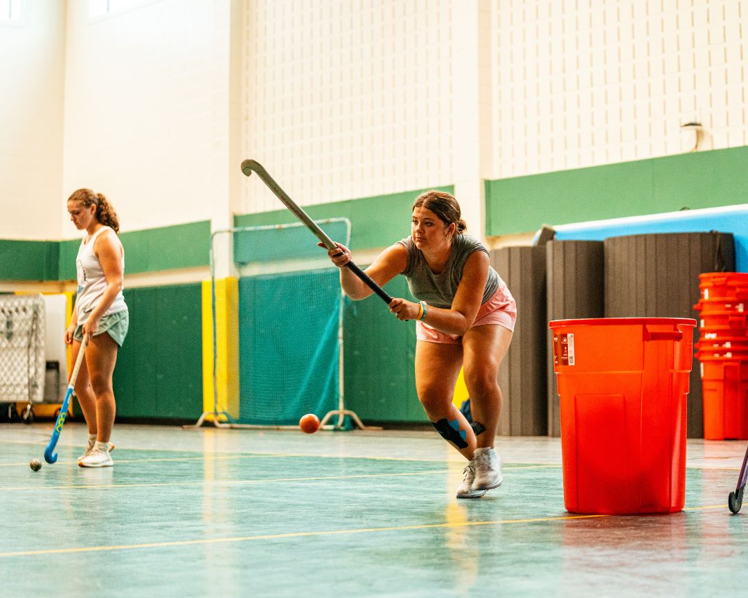 Two girls during field hockey practice indoors at signature sports camp