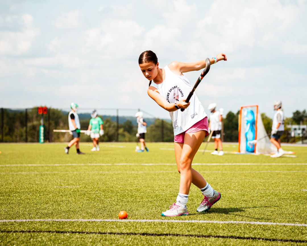 Girl at signature sports camp practicing fundamental field hockey drills