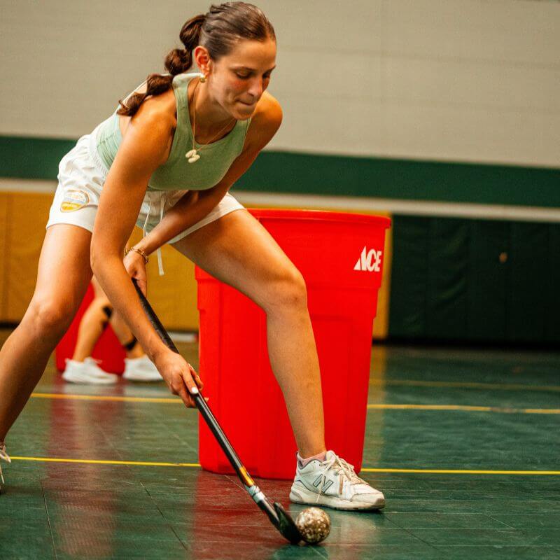 Girl at signature sports camp practicing ball control during field hockey drills