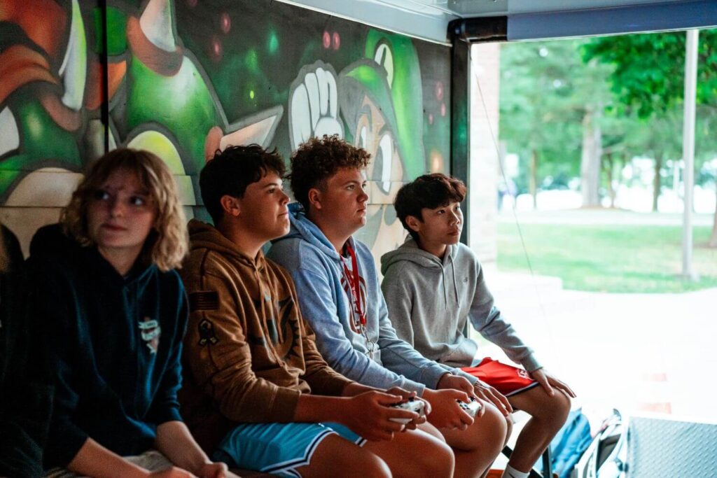 boys at signature sports camp enjoying down time in a mobile game truck