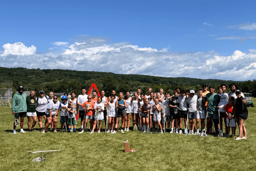 A group of athletes at Signature Sports Camp in New York posing together for a photo after a training session on the field