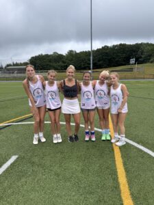 Field hockey girls at Signature Sports Camp stand for a picture with Team USA Field Hockey Pro, Danielle Grega, after their private instruction. 