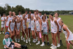 A group of boys and girls at overnight sports camp pose for a photo after practice