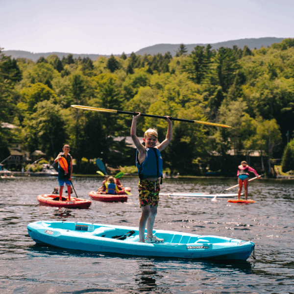 kids stand up paddleboarding on the lake at New England Overnight Sports Camp