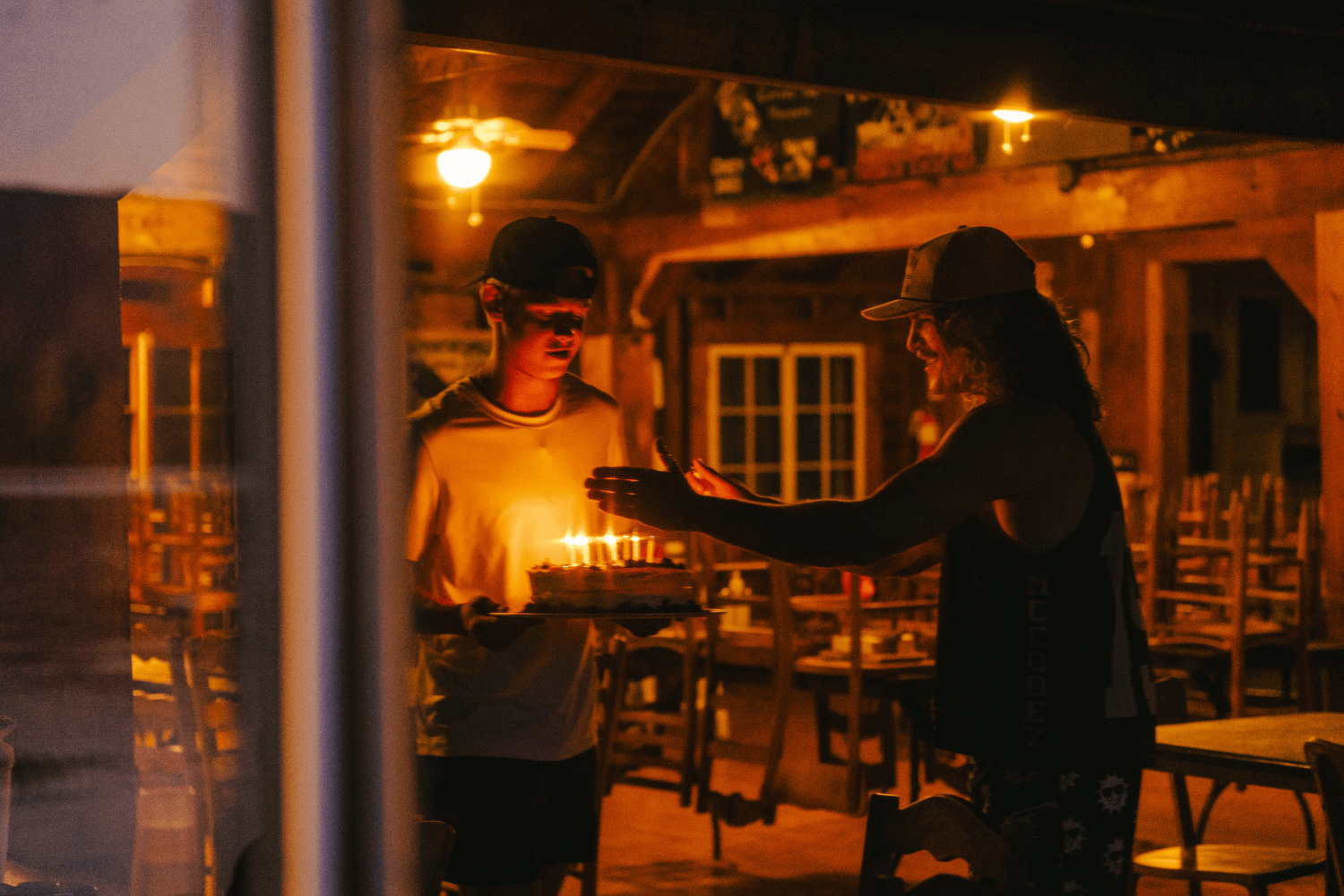Boys lighting birthday cake candles at sports camp