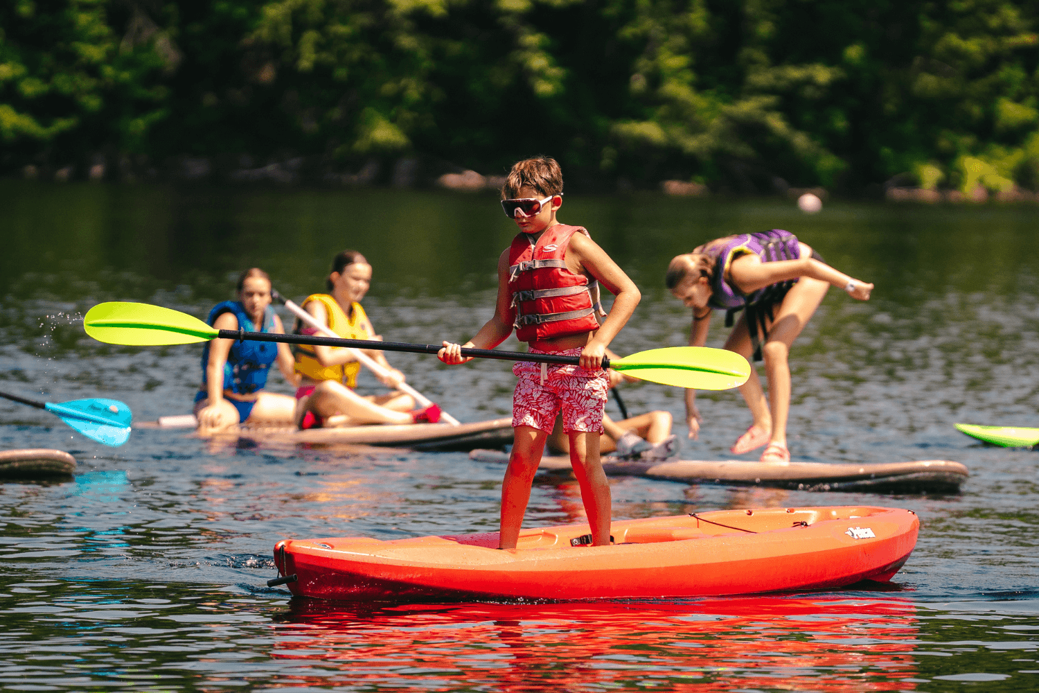 kids stand up paddleboarding at overnight sports camp in new england