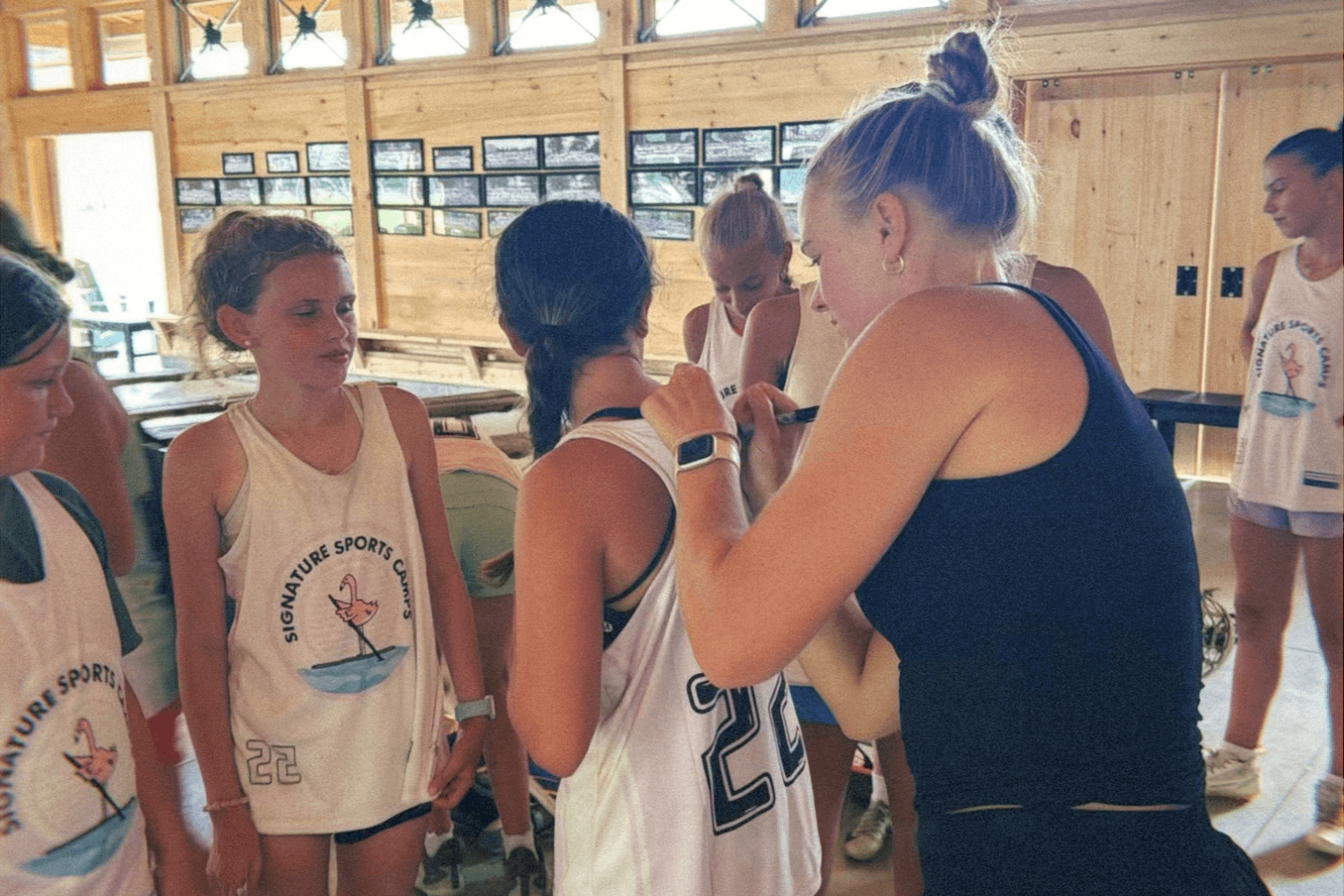 campers at overnight sports camp get their jerseys signed by a lacrosse pro
