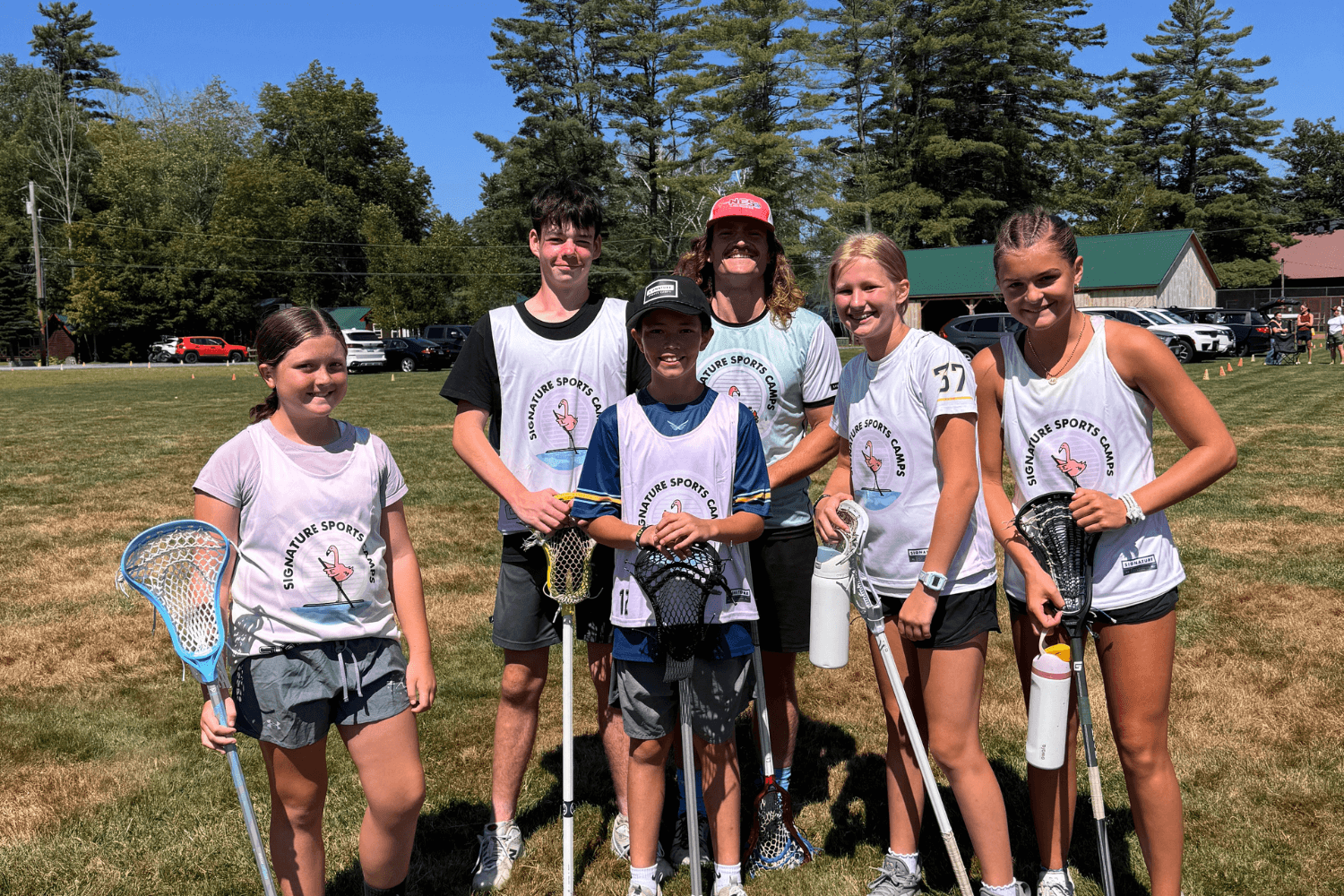 A group of lacrosse players smile for a photo at overnight sports camp in New england