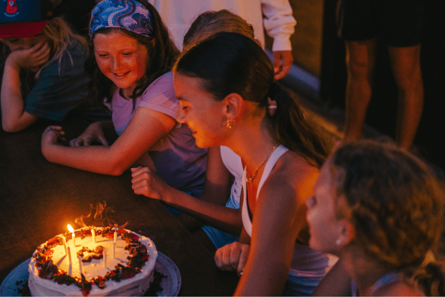 Girl blowing out birthday cake candles at sports camp
