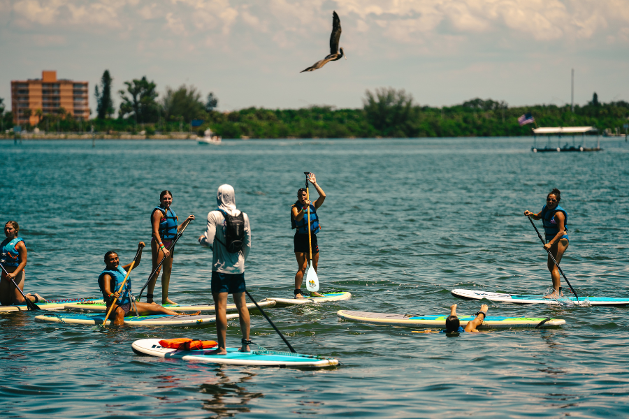 Campers at overnight sports camp paddleboarding on the water