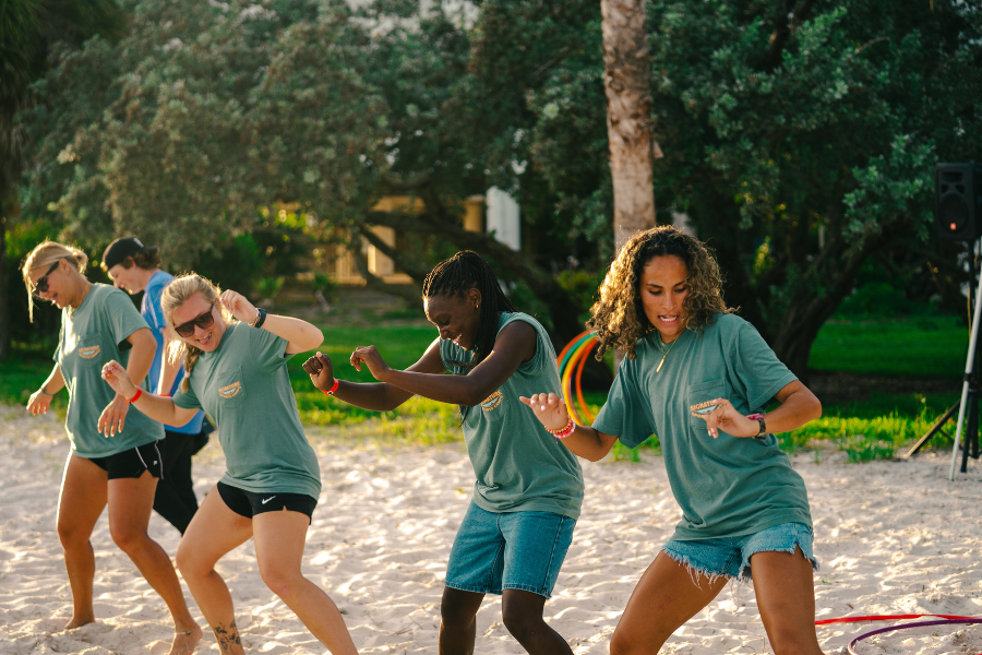 camp counselors at overnight sports camp dancing on the beach