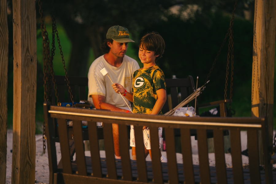 camper at overnight sports camp holding a marshmallow ready to roast