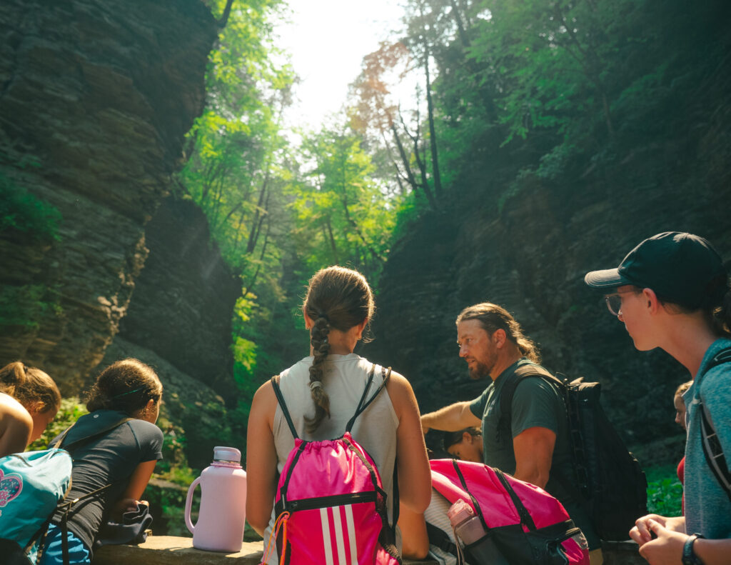 signature sports camp campers listen to the tour guide at Watkins Glen State Park on a camp trip.