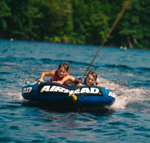 campers smile as they tube in the lakes of the White Mountains in New Hampshire at signature sports camps