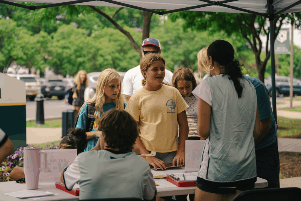 Parents and campers happily checking in at Signature Sports Camps, welcomed by friendly summer camp staff