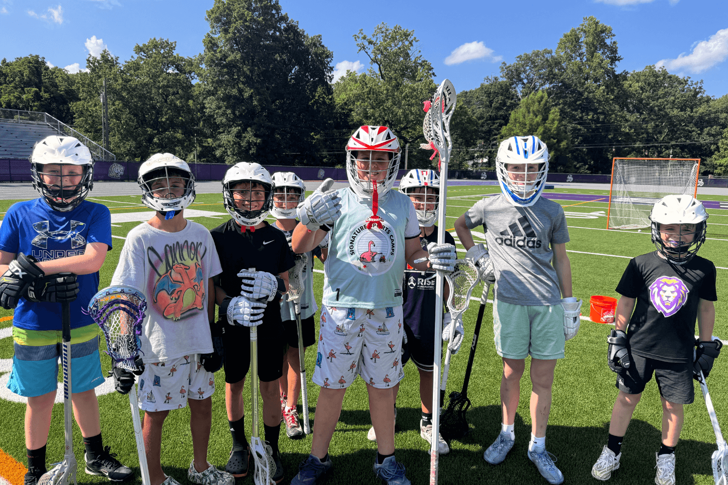 Boys smile for a photo after lacrosse practice at overnight sports camp