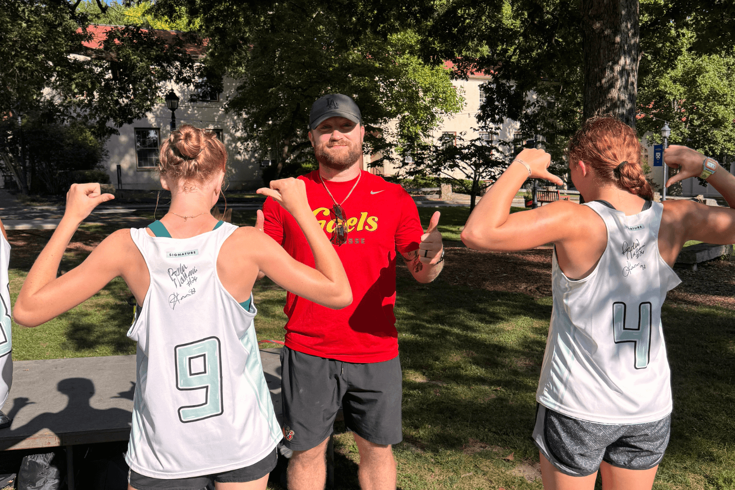 Girls showing off their autographed jerseys with a lacrosse pro