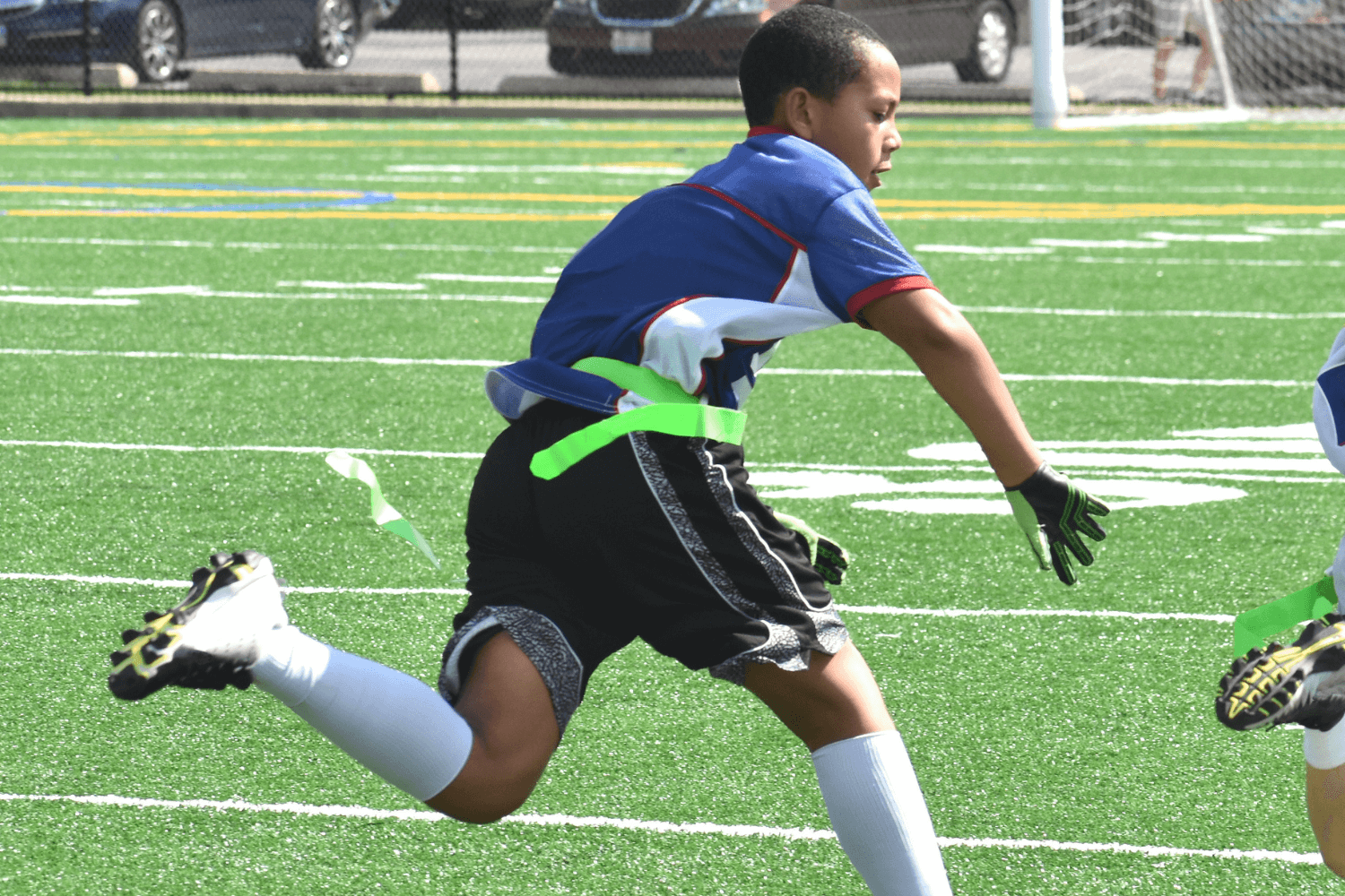 Boy in blue shirt playing flag football