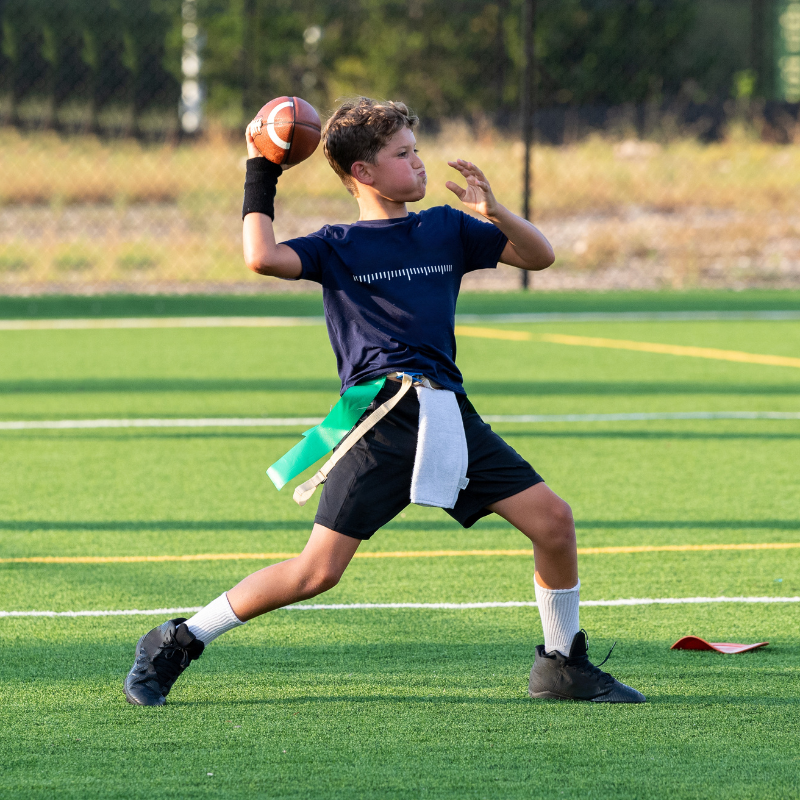 Boy playing quarterback and throwing a football during a game