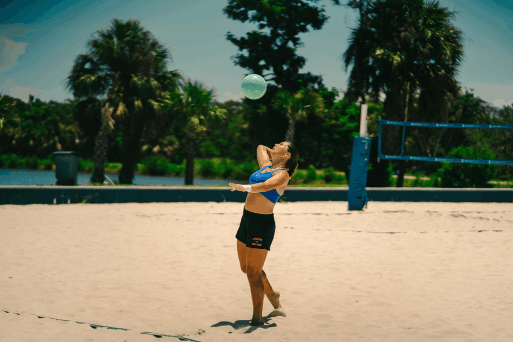 Girl playing beach volleyball passing a ball