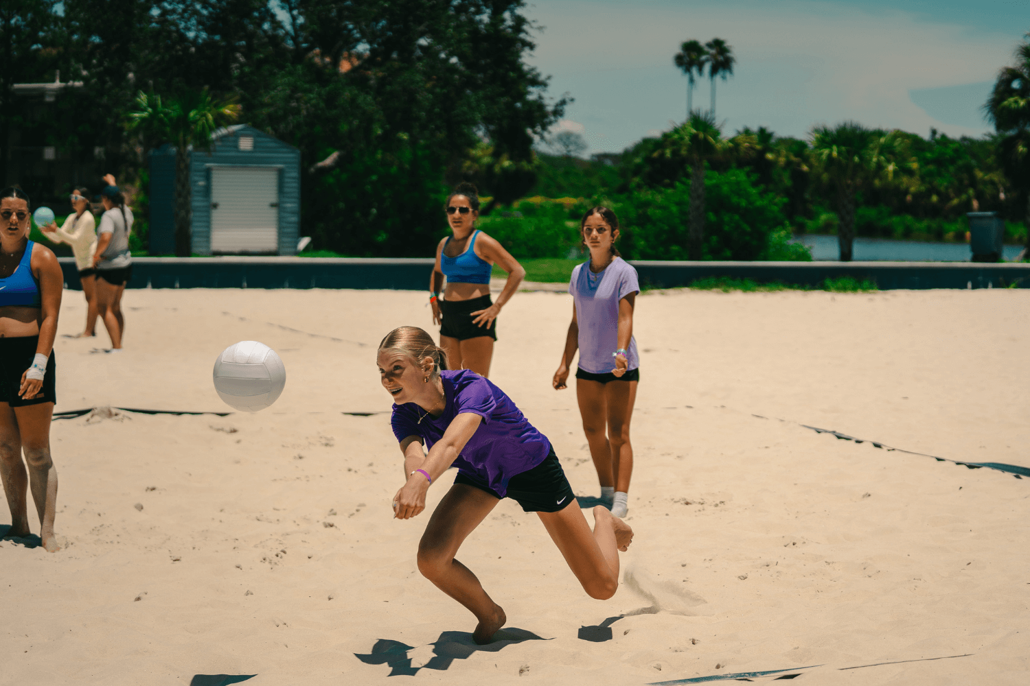 Girl passing a volleyball during a game of beach volleyball at camp