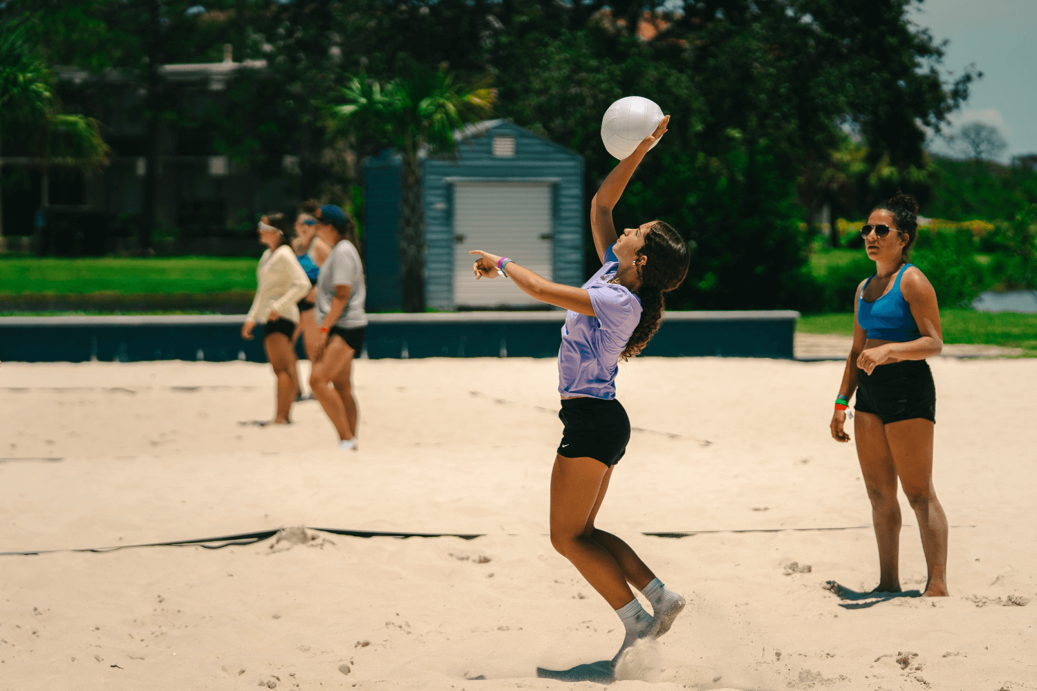 Girl jumping to pass volleyball during summer camp