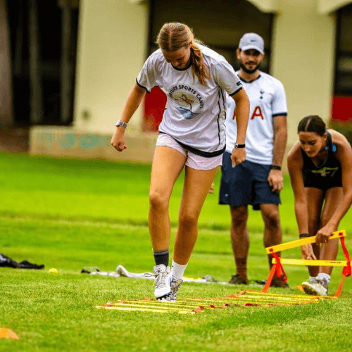girl running ladder drill during speed and agility training at camp
