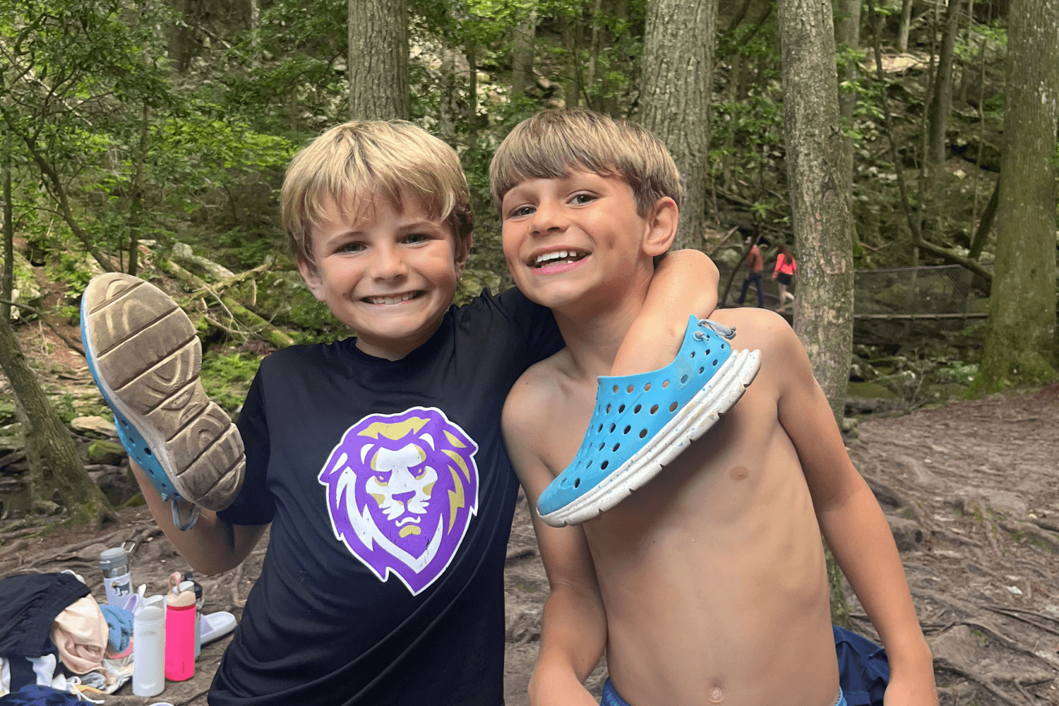Two boys smile for a photo during a hike at summer sports camp