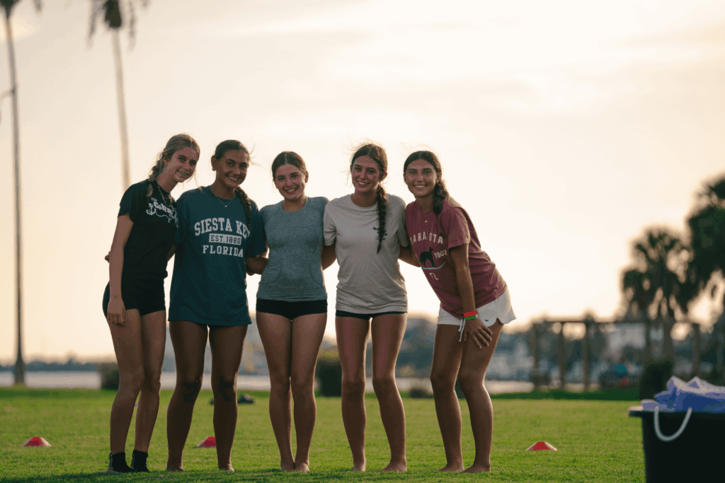 Five girls with their arms around each other smile for a photo at Signature Sports Camps Florida overnight camp