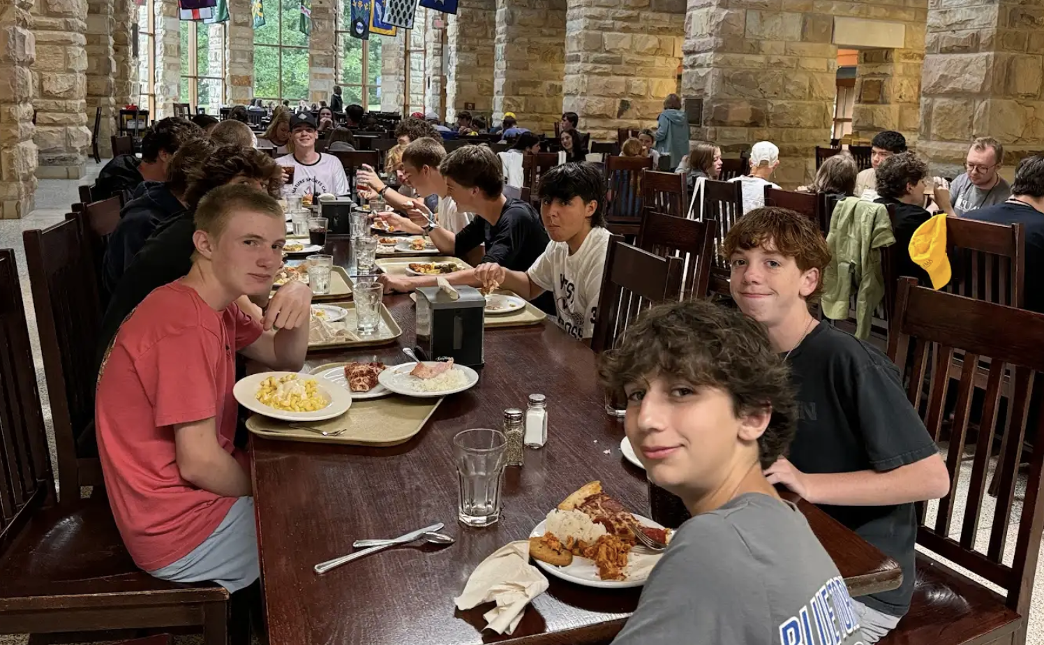 A group of boys enjoying dinner together at Signature Sports Camps, demonstrating the importance of balanced meals and healthy eating habits that support young athletes during their post-holiday nutrition reset.