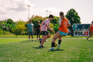 Campers competing in a one v. one on soccer field