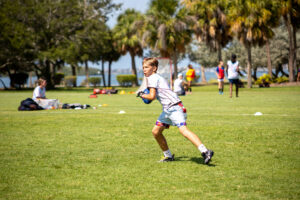 Camper training flag football at overnight sports camp.